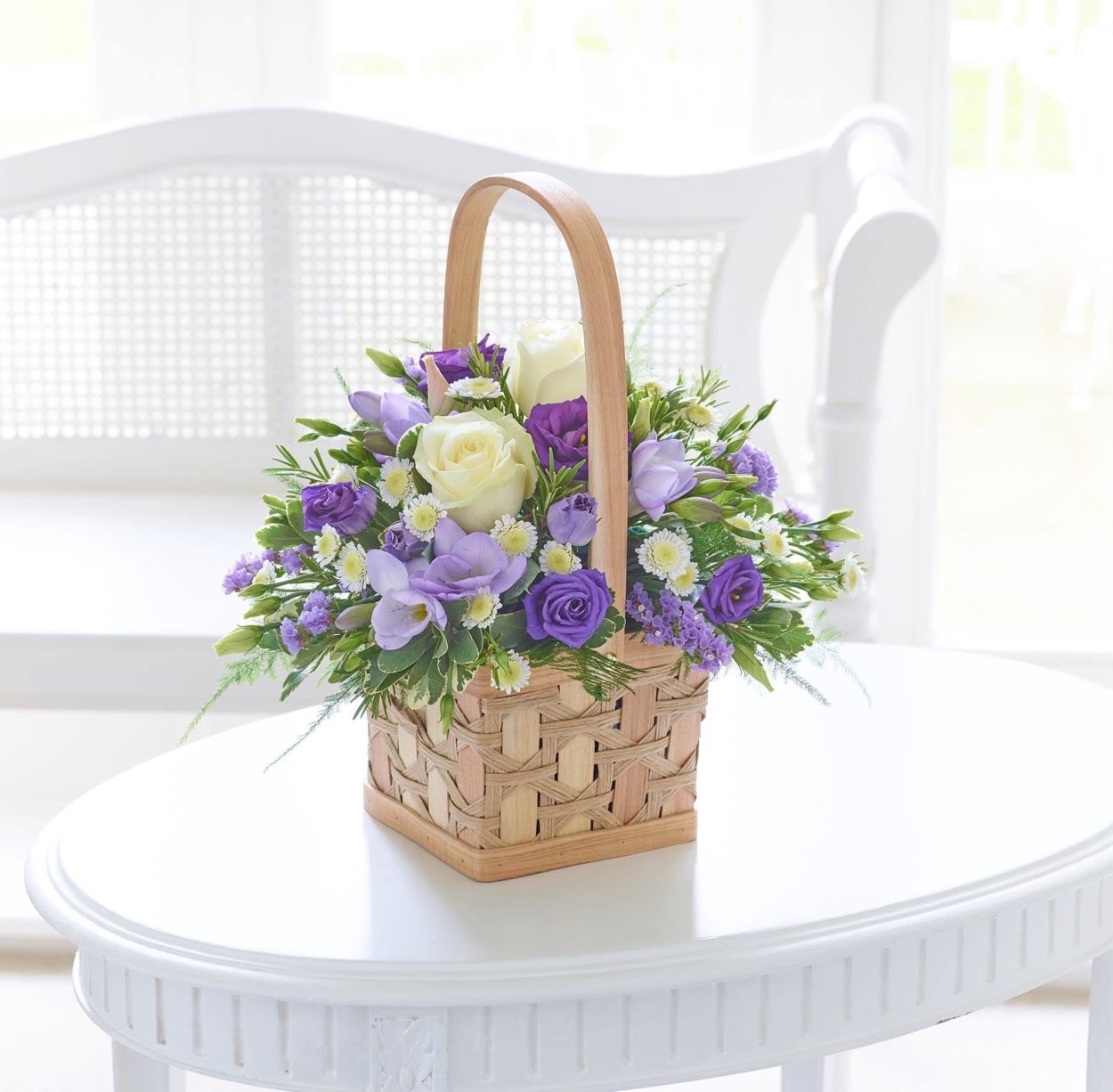 Композиция в корзине из живых цветов в сиреневый тонах