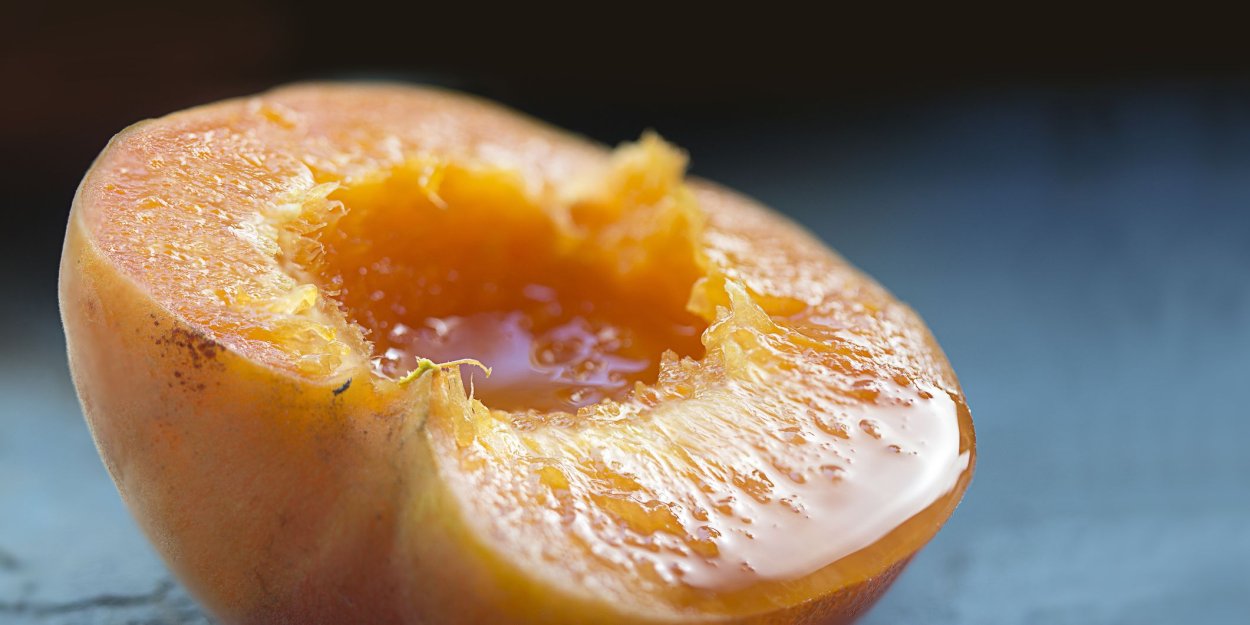 Ест сочный персик