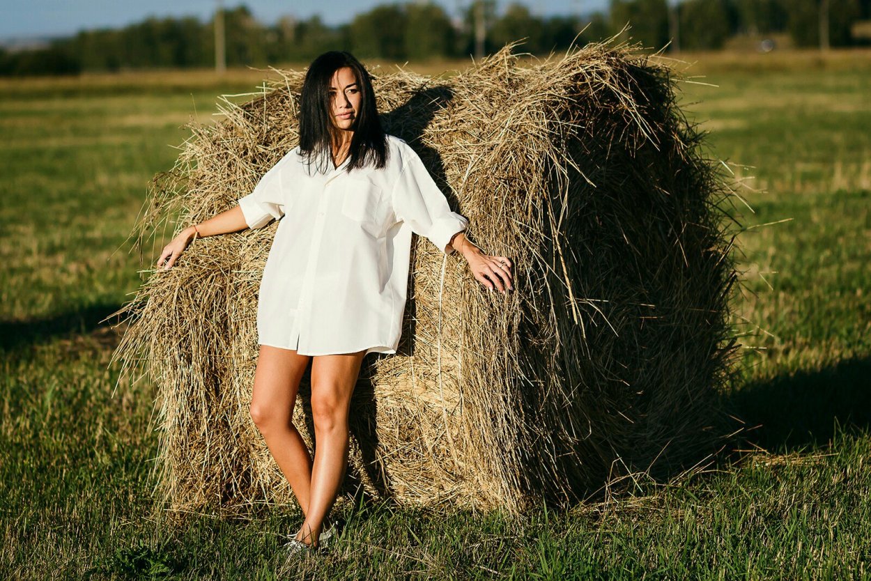 Фотосессия, девушка в белой рубашке и стог сена