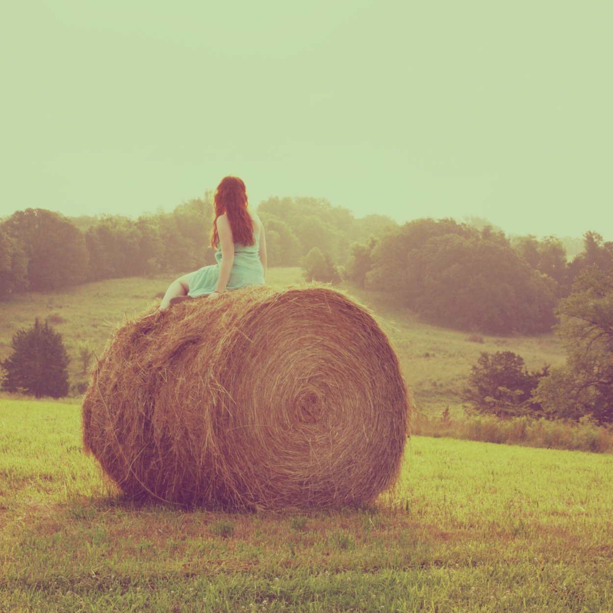 Девушка на стоге сена со спины