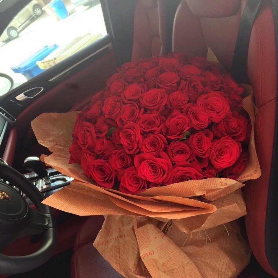 Букет цветов из роз для леди на переднем сиденье машины
