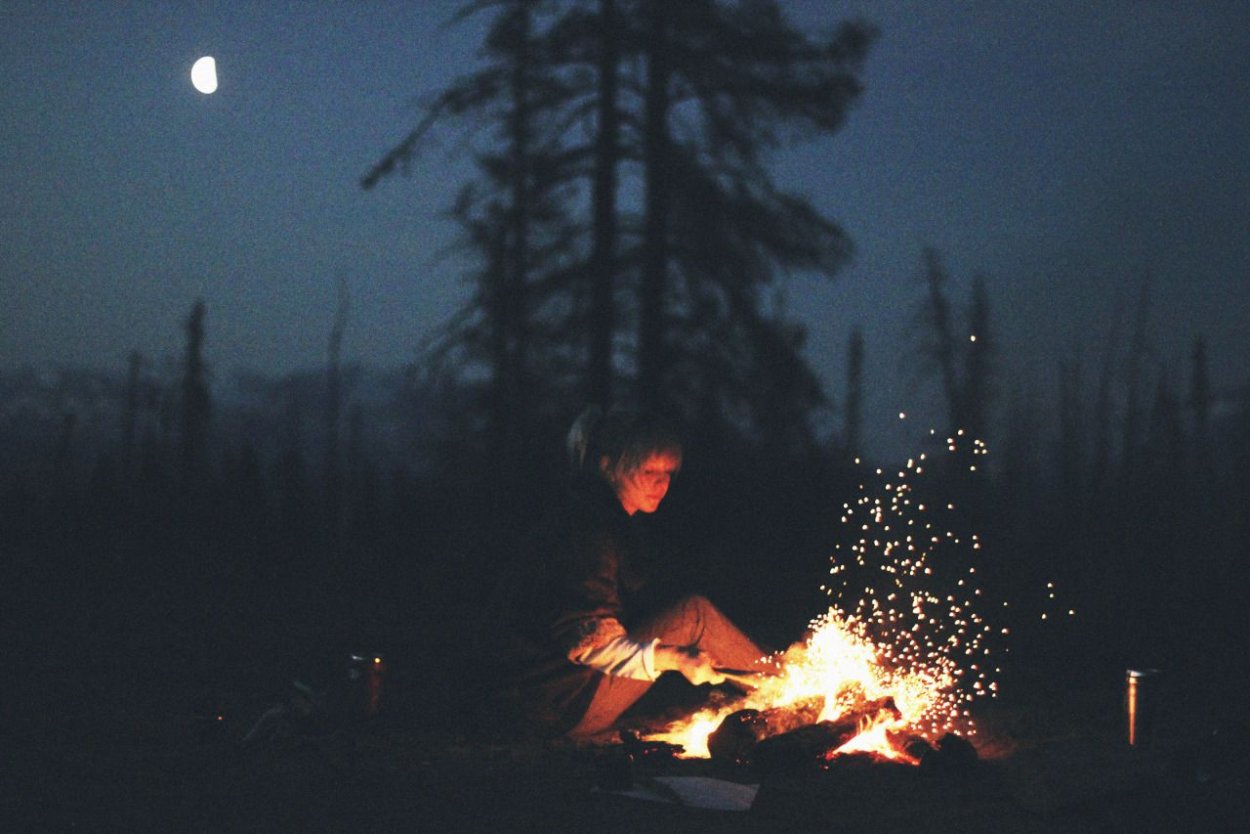 Один у костра в лесу