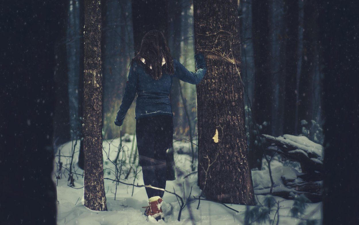 Девушка в зимнем лесу со спины