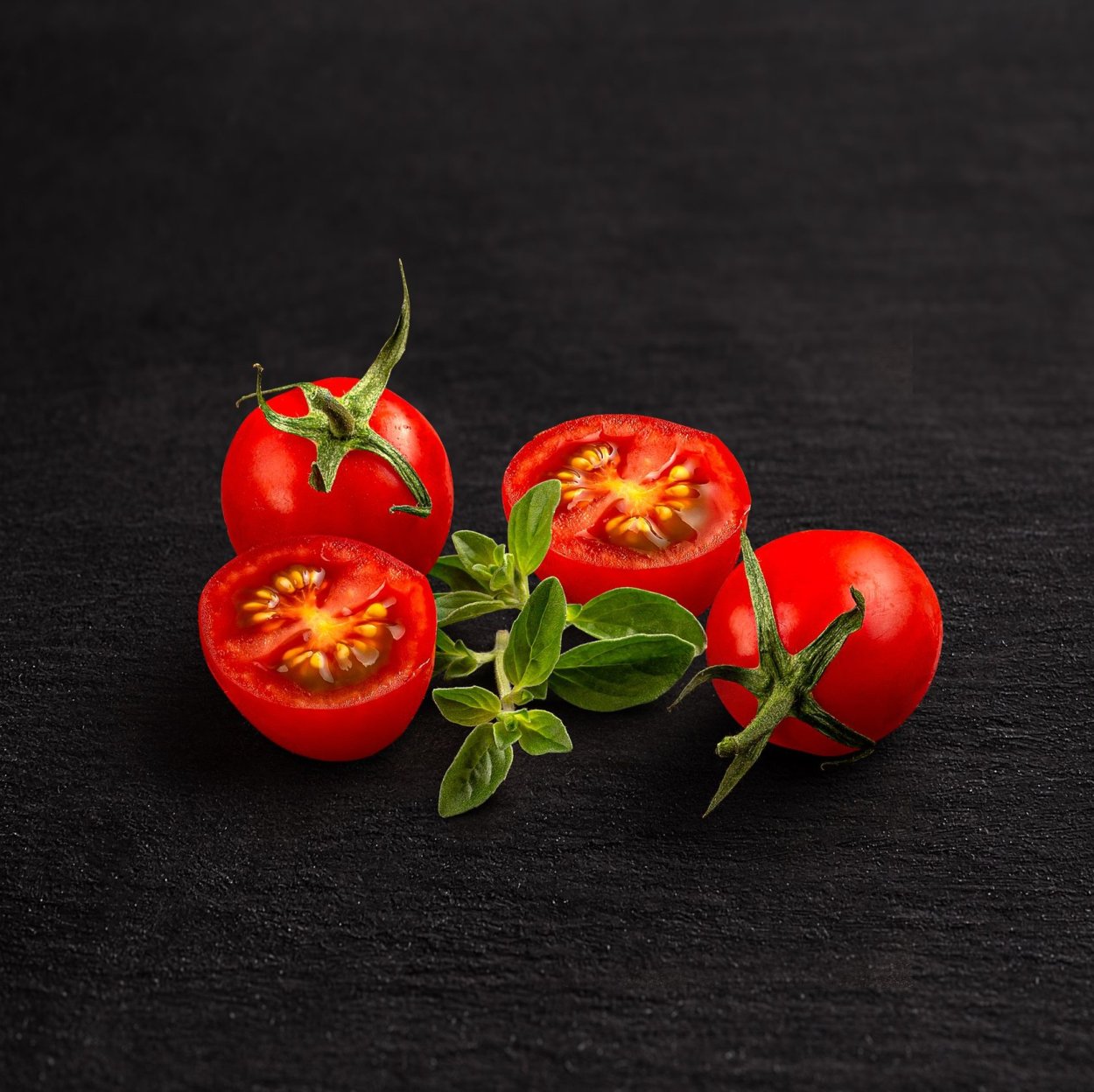 Чери помидоры на черном фоне
