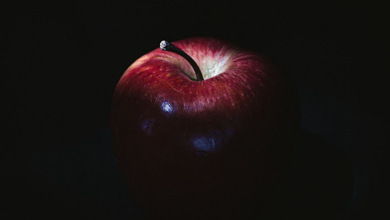 Красное яблоко на черном фоне