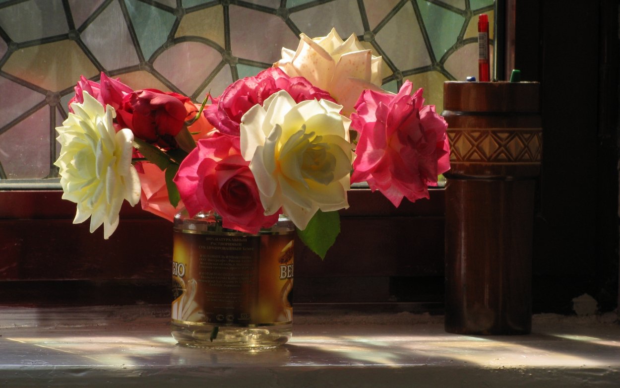 Розы в вазе на окне