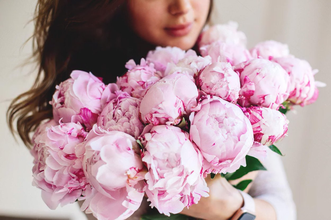 Пионы в руках у девушки